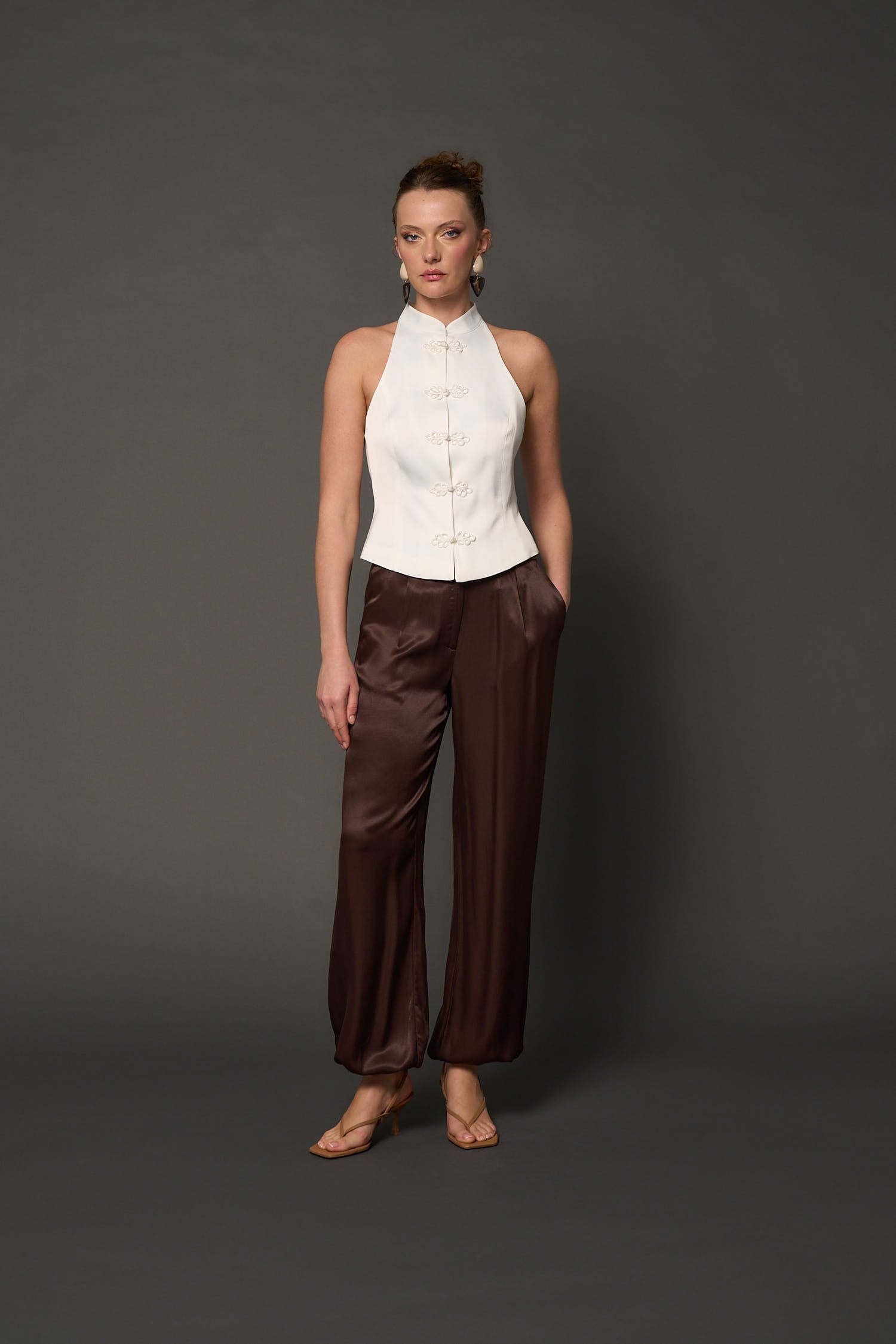 White sleeveless vest with decorative fastenings